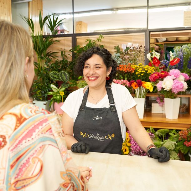 imagen de profesional sonriendo atendiendo a clienta en el mostrador