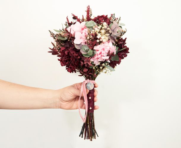 mano con ramo de novia t flores rosas y rojas