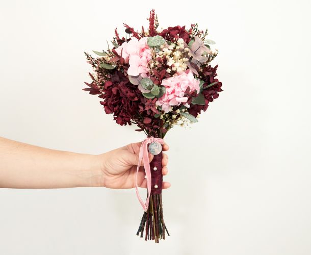 mano con ramo de novia t flores rosas y rojas